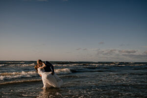 Sesja poślubna nad morzem o zachodzie słońca
